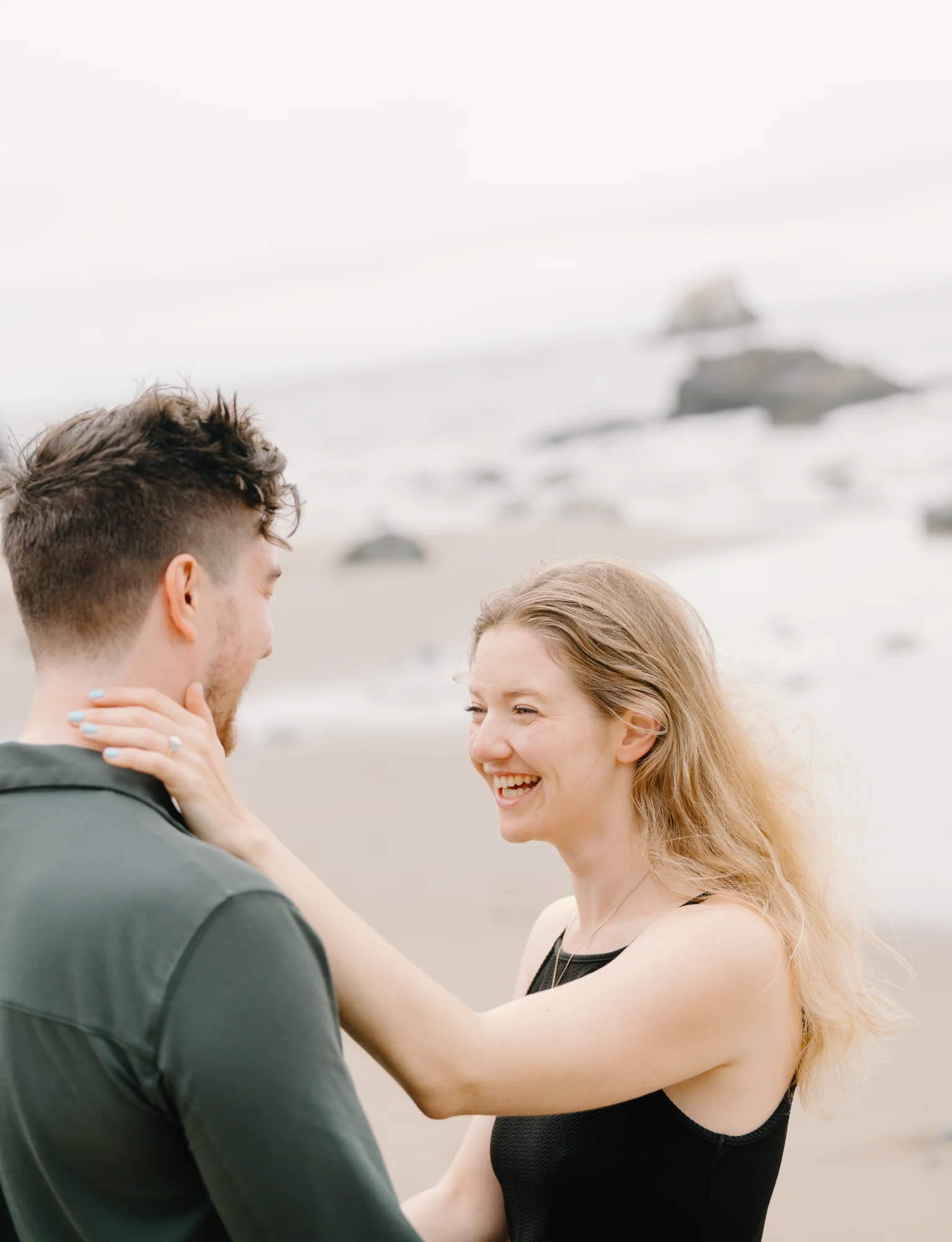 Matt and Amélie smiling together at the beach